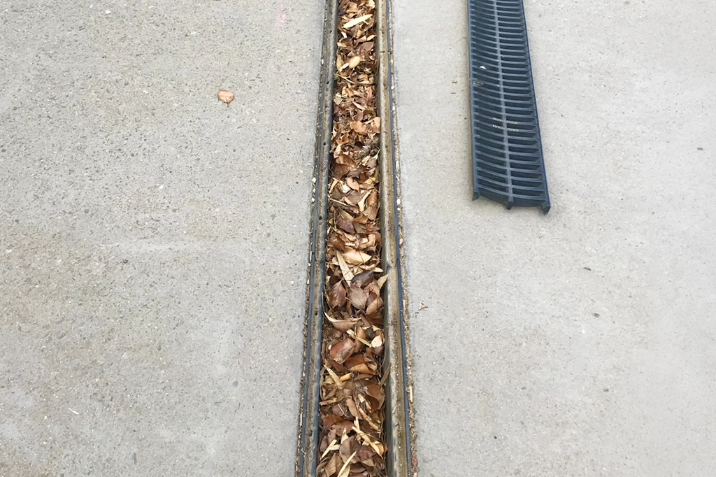 Gutter Sukker - Gutter Cleaning Adelaide home page photo of a strip drain that is full of leaves.